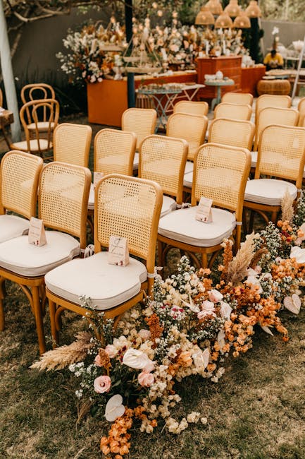 Rows of chairs with floral decorations at an outdoor wedding ceremony setup.